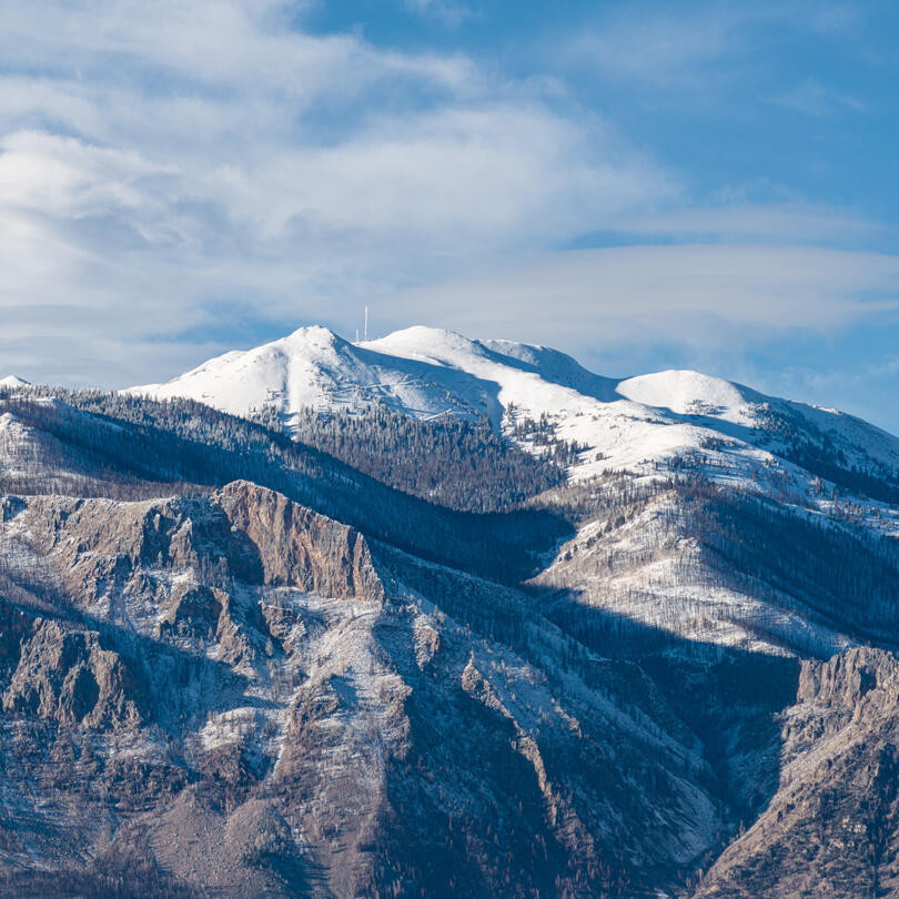A snow covered mountain with cliffs